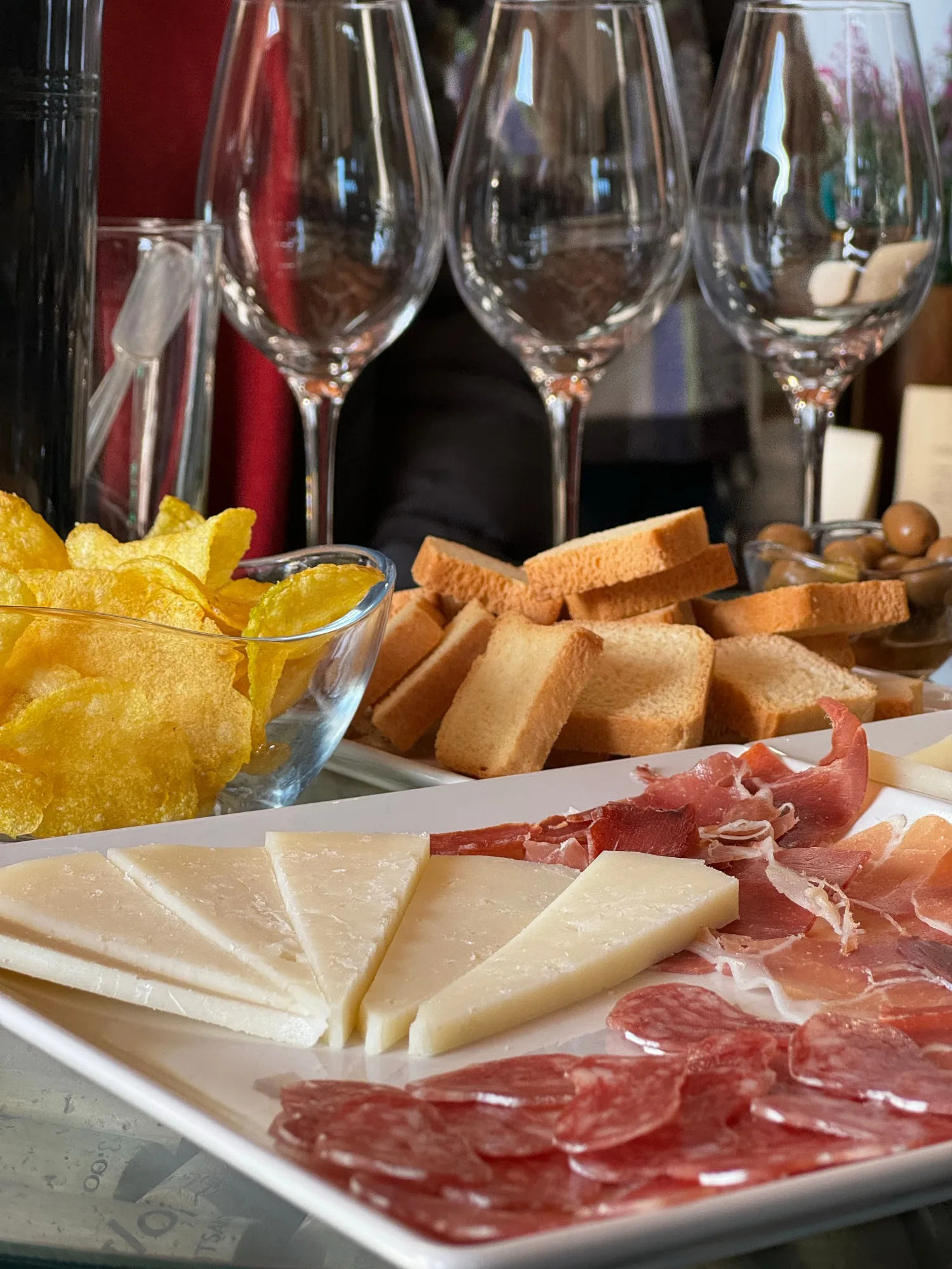 Barra de taberna madrileña, copas de vermú, corte de jamón. Luz natural.